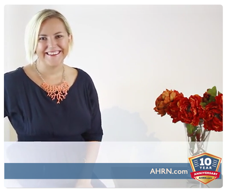 Woman standing next to a vase of flowers