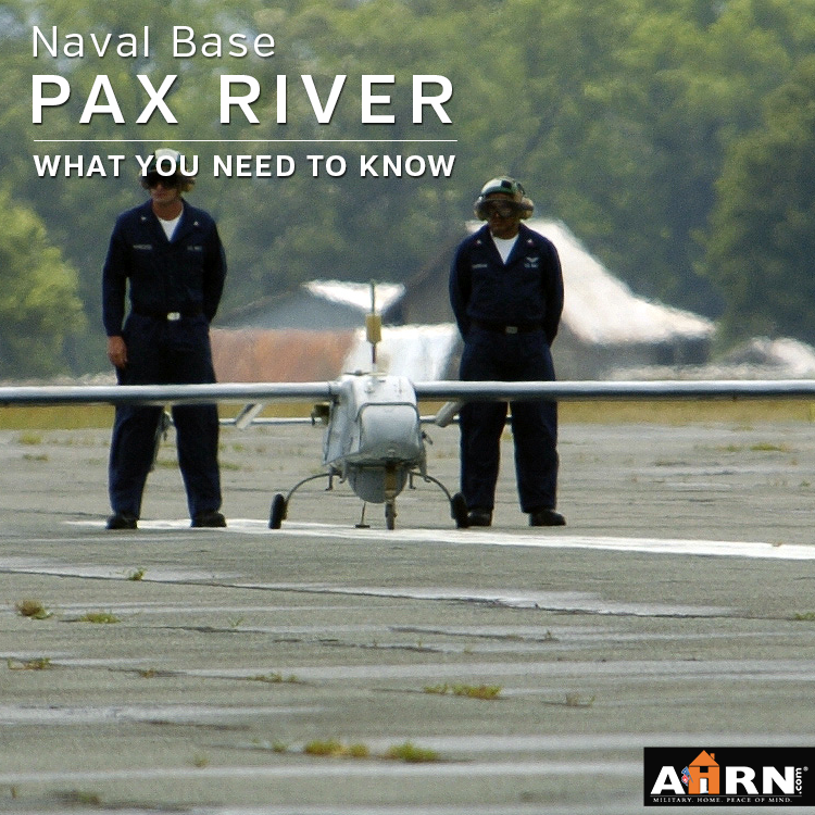 Two men standing next to a small airplane