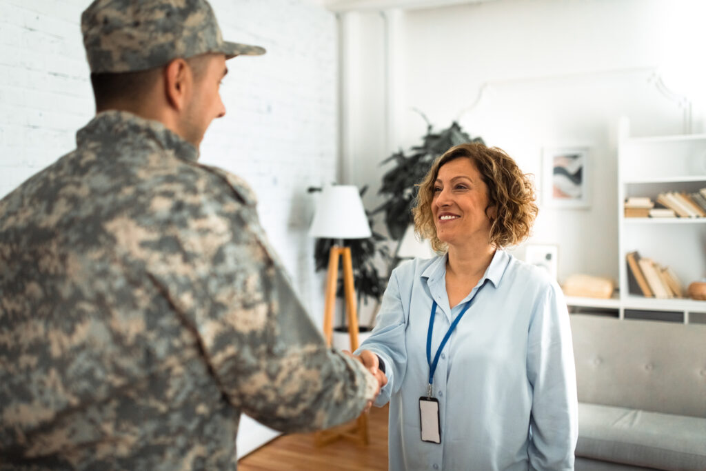 A military personnel shaking hands with a woman